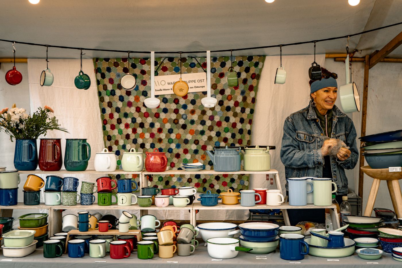 Modern artisan presenting handmade pottery at a curated market stall